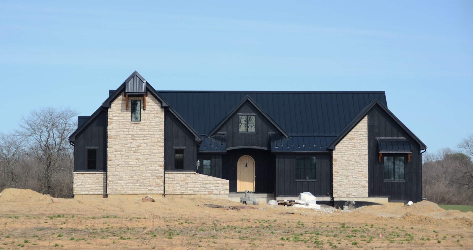 Luxury home construction featuring a modern black and stone exterior in South Florida, emphasizing the importance of professional oversight in major remodels and building projects.