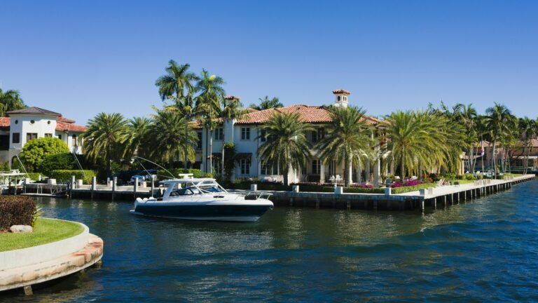 Luxury waterfront property in Delray Beach with palm trees and a boat on the Intracoastal waterway, reflecting the area's upscale residential market.