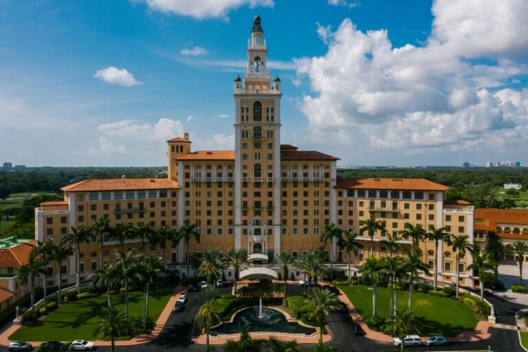 Luxury hotel building with palm trees and fountain in Boca Raton, Florida, representing upscale residential communities and construction management services.